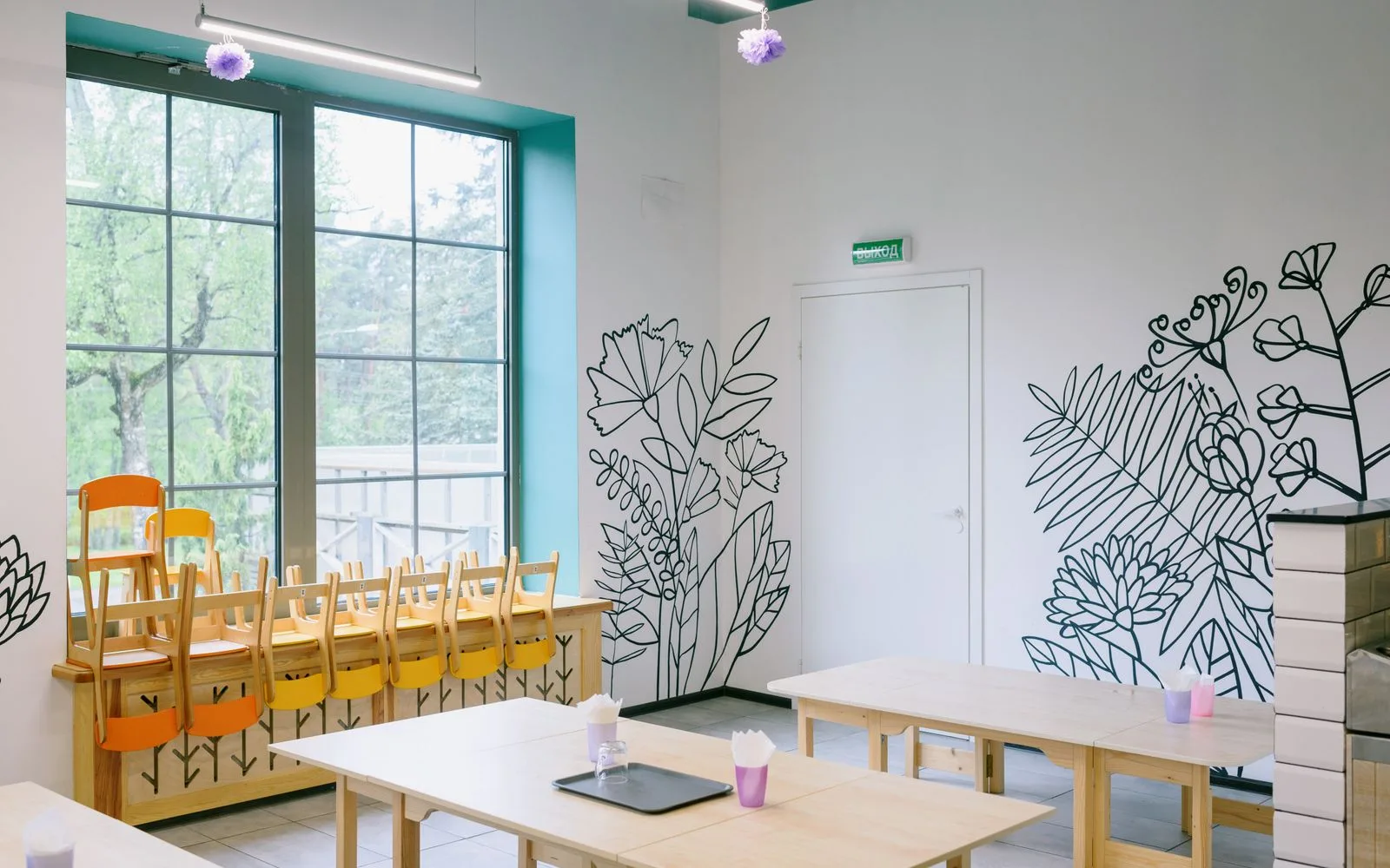 Empty kindergarten classroom with tables and chairs