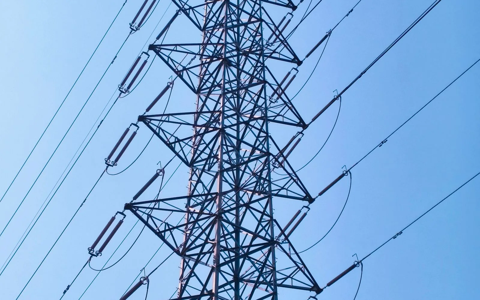 青空を背景にした送電鉄塔