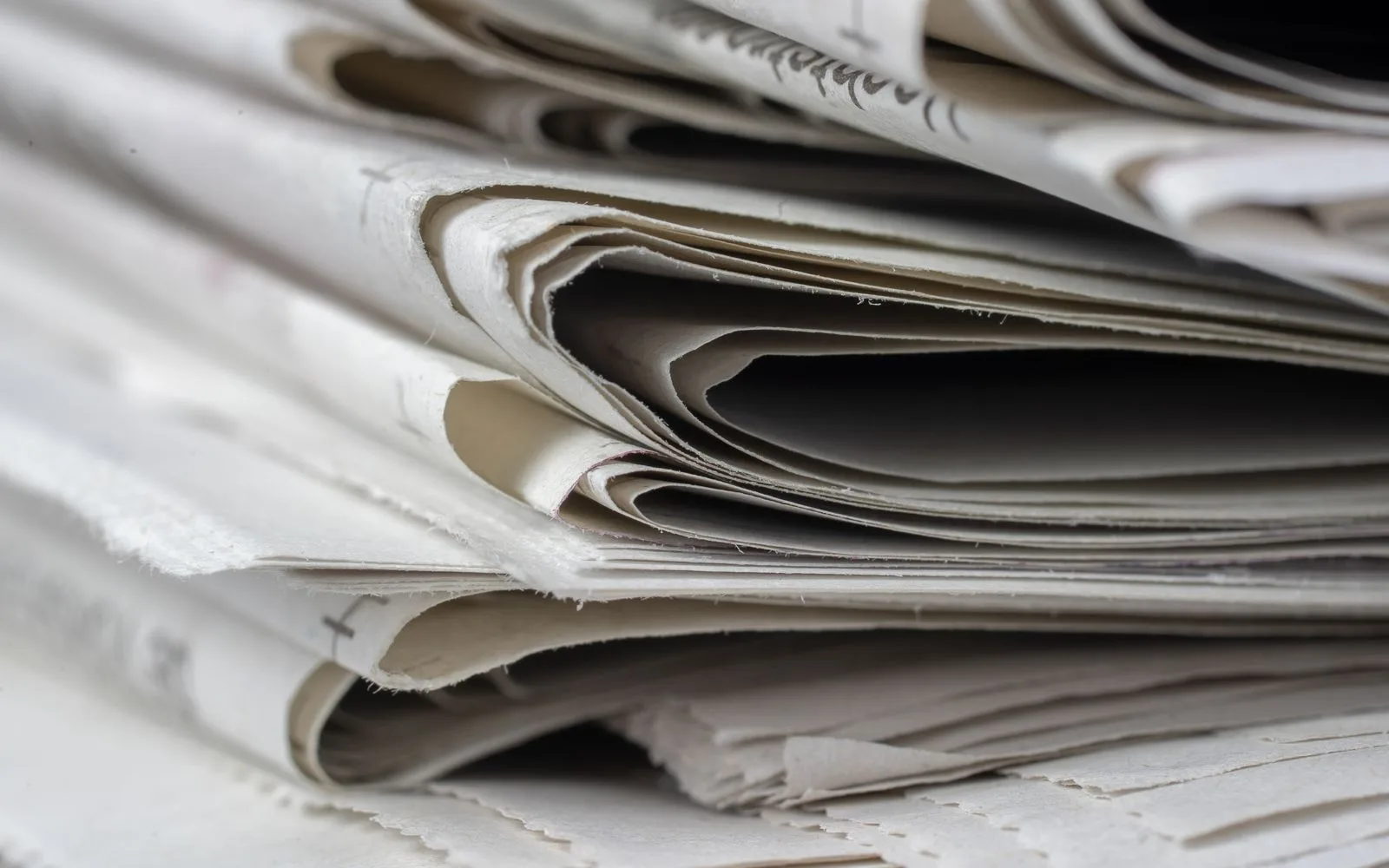 Close-up of folded newspapers stacked together